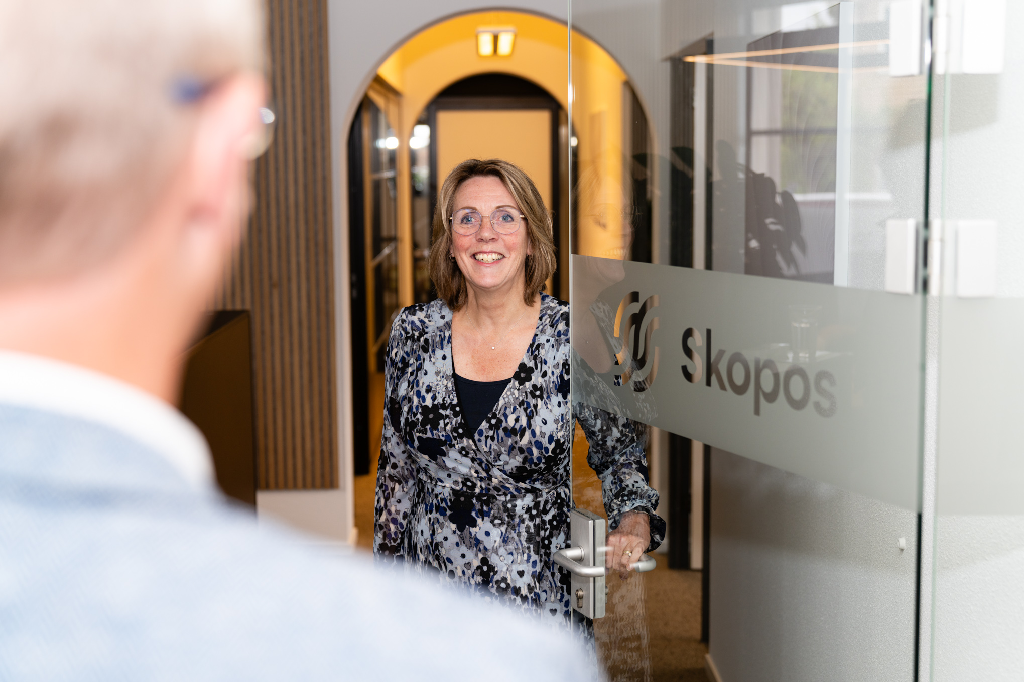 Kennismaken met Skopos voor jouw software-implementatie Consultant van Skopos ontvangt een bezoeker voor een kennismakingsgesprek over software-implementatie en digitale verandering.